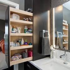Hidden cabinets in a modern bathroom, seamlessly integrated into the wall and mirror for a clean, clutter-free look.