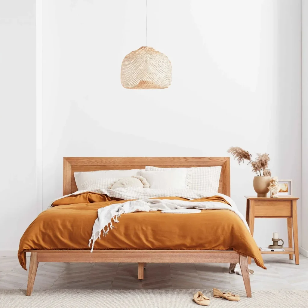 Scandinavian-style bedroom with light wood furniture and minimalist design, featuring multifunctional furniture made from sustainable materials like multilayer board and OSB.