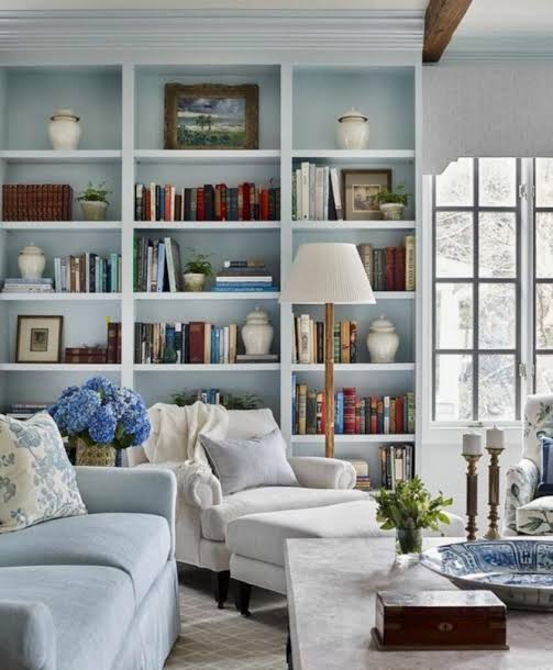 Open bookcase decor with books, vases, and baskets in a hotel-style room