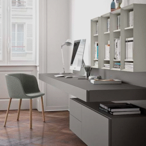 Modern minimalist home office desk with clean-lined tabletop, desktop computer, task lamp and wall shelving; neutral contemporary workspace.