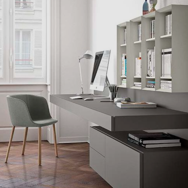 Modern minimalist home office desk with clean-lined tabletop, desktop computer, task lamp and wall shelving; neutral contemporary workspace.