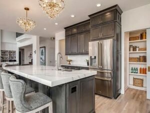 Custom grey kitchen cabinet set with modern island and tall storage wall