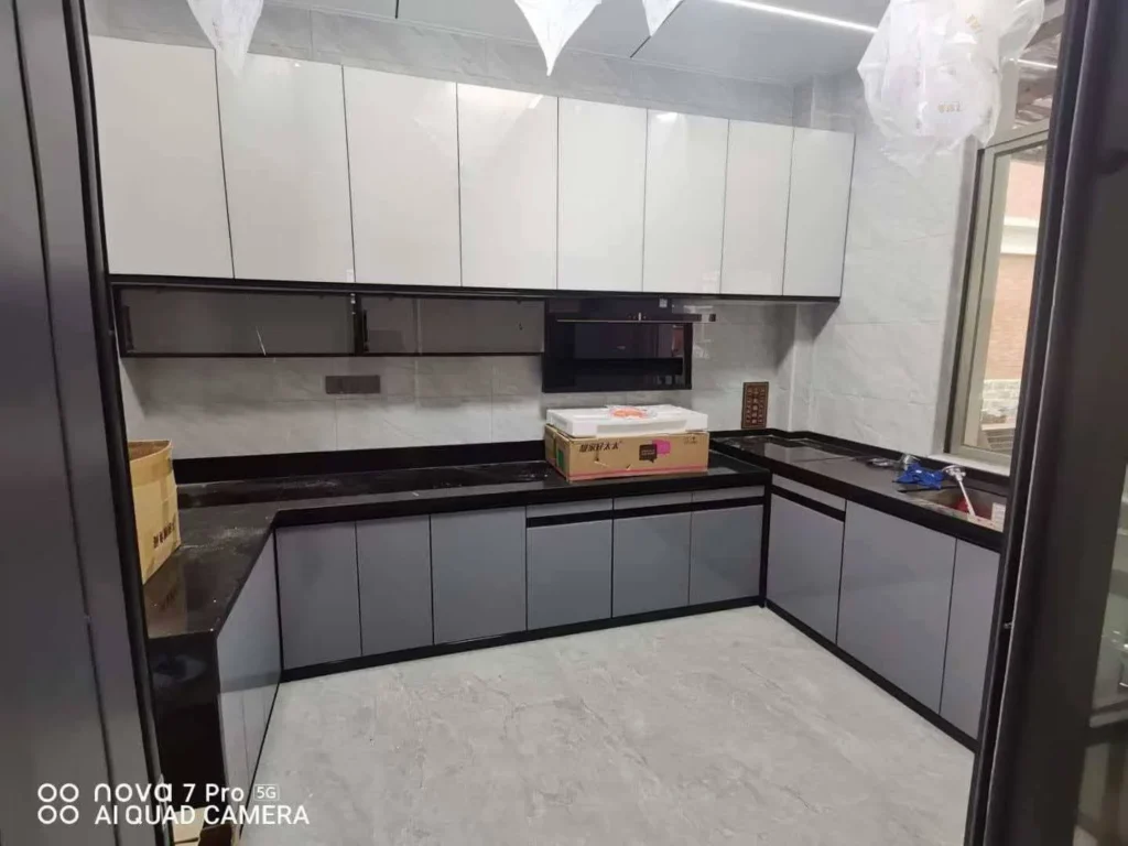 Straight-line flat-panel kitchen cabinets with gray doors and black quartz countertop
