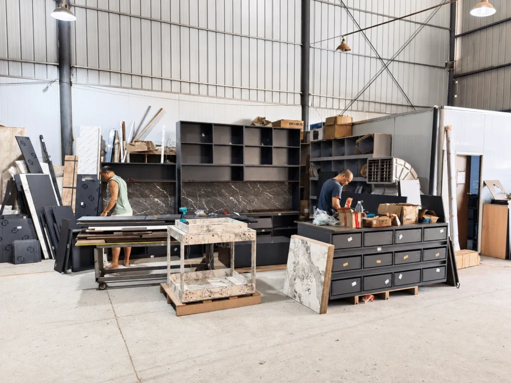 Workers assembling custom panel furniture in an OEM production workshop for a Middle East order.