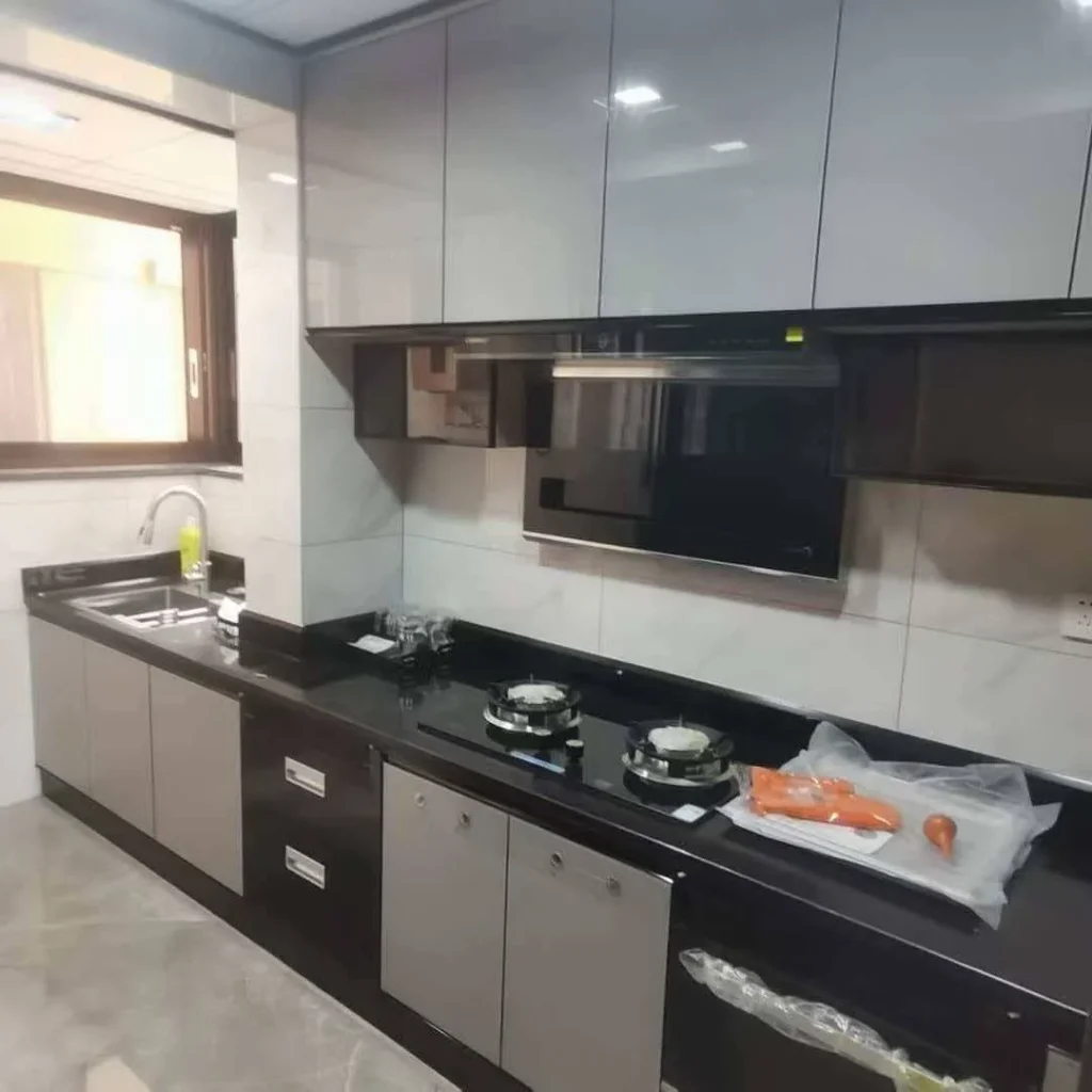 Modern linear kitchen with contrasting gray cabinet fronts and dark stone countertop.