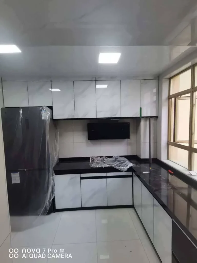 U-shape apartment kitchen cabinets with gray flat-panel doors and dark quartz countertop