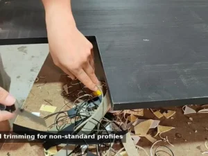 Manual PVC edge finishing on a non-standard panel at an OEM furniture factory
